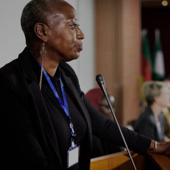 A Middle African Descent Woman Speaking into a Microphone